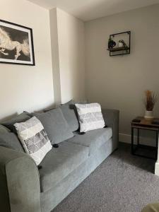 a living room with a gray couch and a table at Oak House - 3bed Townhouse with free parking by ShortStays4U in King's Lynn