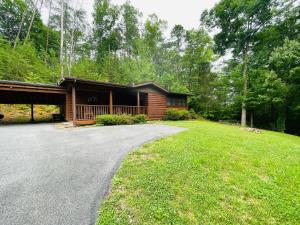 une cabane en rondins avec une allée en face d'une maison dans l'établissement Smoky Mountain Enchanting Haven 3BR2BA Cabin, à Sevierville