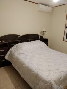 Schlafzimmer mit einem weißen Bett und einem Schreibtisch in der Unterkunft La Solita in Mercedes