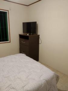 1 dormitorio con cama y vestidor con TV en La Solita, en Mercedes