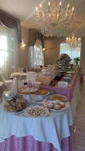 un tavolo con molti piatti di cibo sopra di Hotel Amica a Rimini