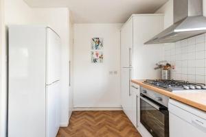 a kitchen with white cabinets and a stove top oven at Spacious light flat in fantastic location! in Eton