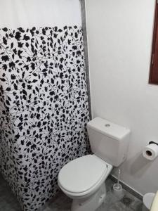 a bathroom with a toilet and a black and white shower curtain at Depto Acogedor cómodo y súper luminoso en km 7,500 in San Carlos de Bariloche