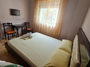 a bedroom with a bed and a table and a window at Hotel Brace in Gjirokastër