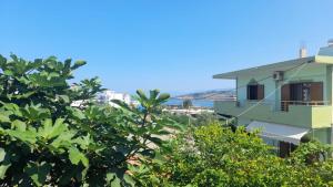 vistas a un edificio con árboles en el primer plano en Vita Apartament, en Ksamil