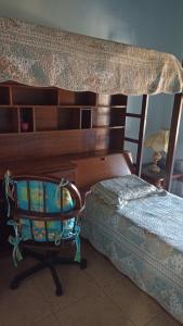 1 dormitorio con cama, escritorio y silla en CASA DE CAMPO A TOCA en Guararema