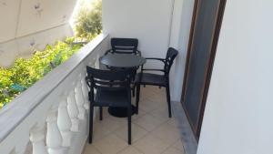 Un pequeño balcón con 2 sillas y una mesa. en Vita Apartament en Ksamil