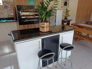 瓜拉雷馬的住宿－CASA DE CAMPO A TOCA，厨房里有一个岛,上面有凳子和植物