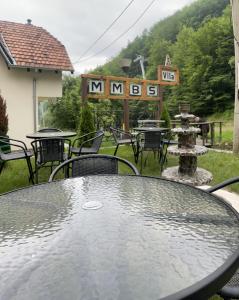una mesa de cristal con sillas y un cartel que lee musgo en Vila MMBS en Brzeće