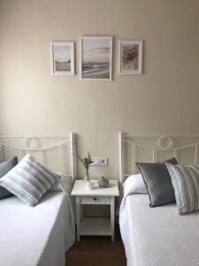 ein Schlafzimmer mit 2 Betten und einem Tisch mit einem Nachttisch in der Unterkunft VIVIENDA VACACIONAL "EL CANXILÓN" Situada en Lastres - Zona Oriente de ASTURIAS - Casa independiente - Terraza con vistas al mar a 800 m de la playa in Llastres