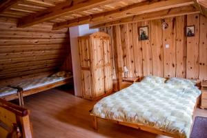 - une chambre avec un lit dans une cabane en rondins dans l'établissement Gospodarstwo Agroturystyczne Kazimierz Januszewski, à Dziemiany