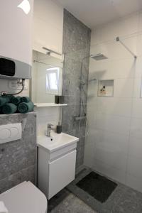 La salle de bains est pourvue de toilettes, d'un lavabo et d'une douche. dans l'établissement House La Vista Hvar, à Hvar