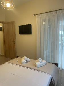 a bedroom with a bed with towels on it at Backyard houses in Toroni