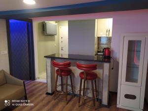 a kitchen with a bar with three red stools at The Sweet Building Esso in Istanbul