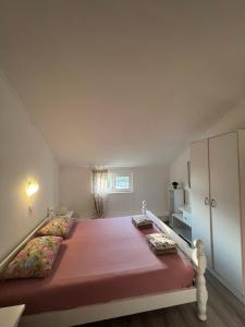 ein Schlafzimmer mit einem großen Bett mit rosa Bettwäsche und Kissen in der Unterkunft Etno village Mihailovic II in Herceg-Novi