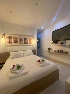 una camera da letto con un grande letto bianco con due asciugamani di La casa di mare ad Agios Gordios