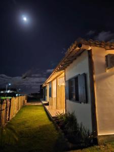Una casa de noche con la luna en el cielo en Vila Aratu Corumbau en Corumbau