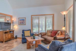 a living room with a couch and a tv at Modoc - Unit 16 in Sunriver