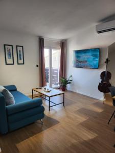 sala de estar con sofá azul y mesa en Apartman LIBRA, en Kaštela