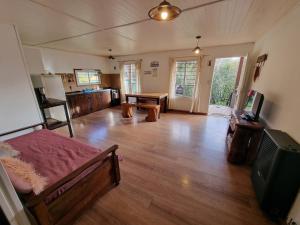 a room with a bed and a kitchen with a table at Villa Amalia in San Carlos de Bariloche