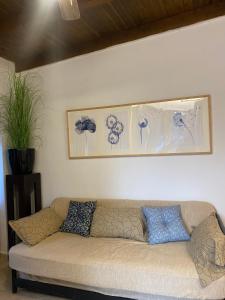 un divano in soggiorno con immagini appese al muro di La casa di mare ad Agios Gordios