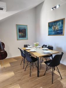 comedor con mesa, sillas y guitarra en Apartman LIBRA, en Kaštela