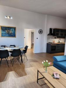 uma sala de estar com um sofá azul e uma mesa em Apartman LIBRA em Kaštela