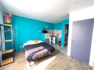 1 dormitorio con paredes azules y 1 cama. en Société Key-s Meaux/Cerf3/Disney en Meaux