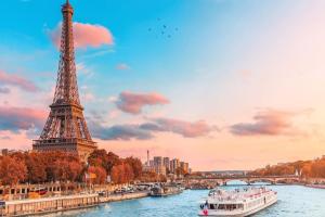 a river with a boat in front of the eiffel tower at Appartement Cerf3-Centre ville Meaux-Gare-Disney in Meaux
