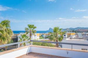 a balcony with palm trees and the ocean at Villa Sa Marinada | 100m de Mar in Sant Josep de sa Talaia