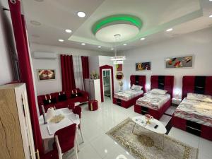 een woonkamer met rode meubels en een groen plafond bij Studio near Tirana Airport 2- SELF Check-in Free Parking in Valjiosi