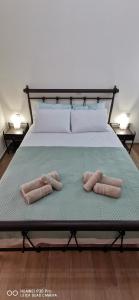 Dos toallas en una cama con dos almohadas. en Η Αρμενόπετρα, en Yerolimin