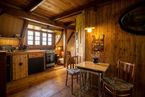 a kitchen with a table and chairs in a cabin at Paradise Cottage - Chalupa v Ráji in Čtveřín