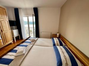 a large bed in a room with a window at Hotel Buenavista Beach House Trogir in Trogir