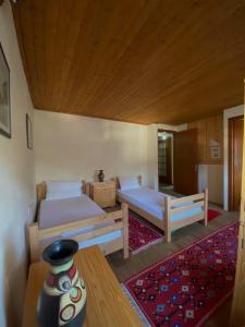 a bedroom with two beds and a table with a vase at Teo’s Guest House in Berat