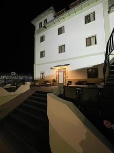 a large white building at night with a stairway at Hotel Oltenia in Eforie Sud