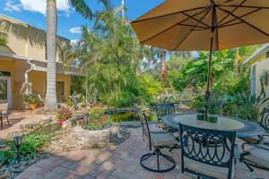 a patio with a table and an umbrella at Banyan House Vacation Rentals in Venice