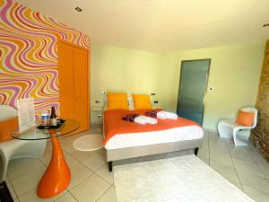 a bedroom with a bed and a table and a chair at La Ferme du Bois - Piscine et Spa in Plottes