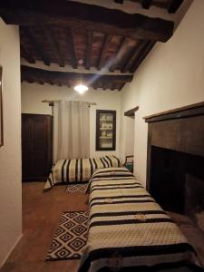 Duas camas num quarto com lareira em Al Podere del Nonno Romolo em Sansepolcro