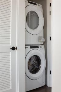 a washer and dryer in a corner of a room at 'Cloud 10' A Luxury Downtown Condo with Panoramic City and Mountain Views at Arras Vacation Rentals in Asheville