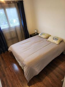 een bed met twee kussens erop in een slaapkamer bij Appartement in Genay