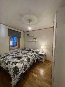 um quarto com uma cama e um candeeiro num piso de madeira em Stylish Vintage Home in the Heart of the City em Trondheim