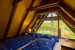 Bett mit blauen Kissen in einem Zimmer mit Fenster in der Unterkunft Paradise Cottage - Chalupa v Ráji in Čtveřín