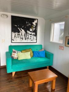 a green couch in a room with a table at Paraiso Flotante in San Fernando