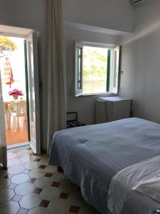 1 dormitorio con cama y ventana grande en Hotel Villa Antonio en Isquia