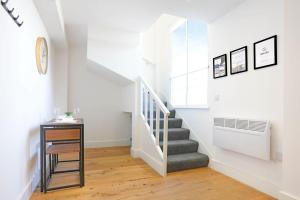 a staircase in a home with white walls and wood floors at Central Buckingham Apartment #6 with Free Parking, Pool Table, Fast Wifi and Smart TV with Netflix by Yoko Property in Buckingham