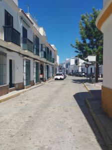 una calle en una ciudad con coches aparcados en la calle en APARTAMENTO SOL, en Chipiona