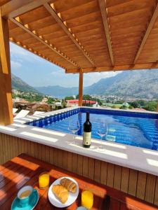 einen Tisch mit einer Flasche Wein und Gläsern auf dem Balkon in der Unterkunft Villa Vista Real in Kotor