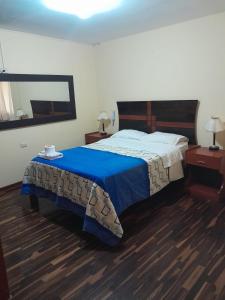 ein Schlafzimmer mit einem großen Bett mit einer blauen Decke in der Unterkunft HOTEL CASTILLO MAGICO (EX CHAVIN SEÑORIAL? in Barranca
