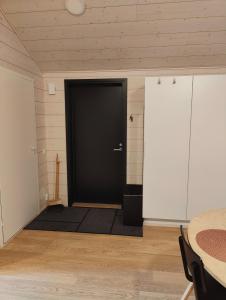 - une porte noire dans une chambre dotée d'un tapis noir dans l'établissement Minikoti, à Oulu